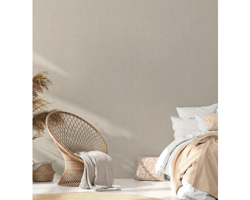 Heller Schlafraum mit Korbsessel, Bett und dekorativen Elementen für ein gemütliches Ambiente.