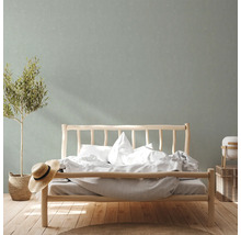 Helles Schlafzimmer mit Holzbett, Pflanze und neutraler Dekoration