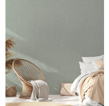 Heller Raum mit Rattansessel, Bett und Textilien für ein gemütliches Ambiente.