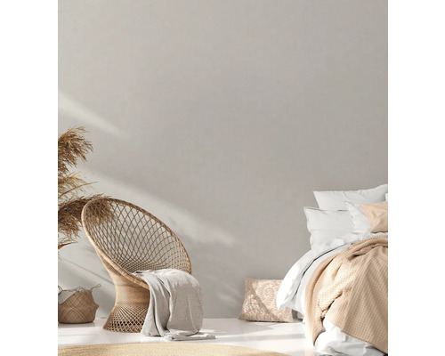 Helles Schlafzimmer mit Korbsessel und Doppelbett