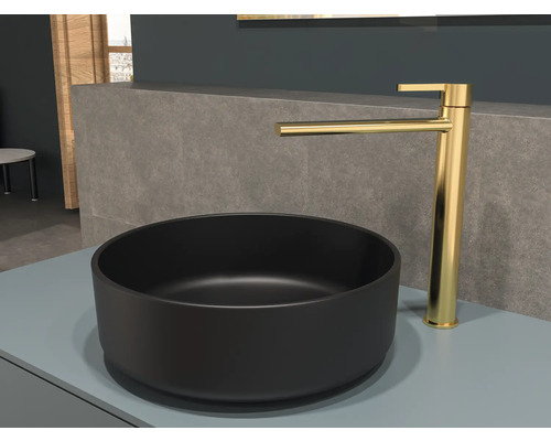 Schwarzes Aufsatzwaschbecken mit goldener Armatur auf einer Ablage