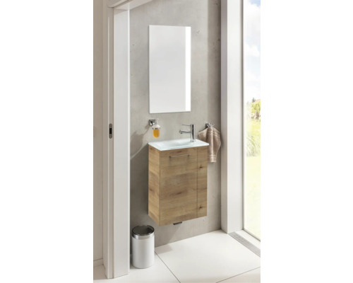 Badezimmer mit Waschtisch, Spiegel, Seifenspender und Handtuchhalter an der Wand