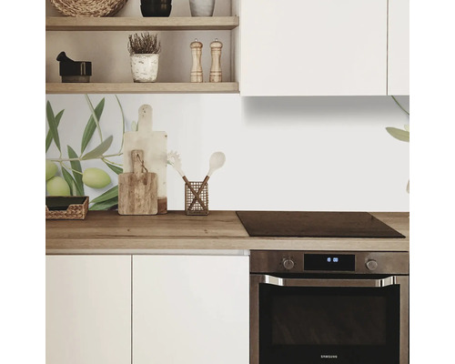 Küchenszene mit weißen Schränken, Holzarbeitsplatte und Olivenzweig-Motiv als Spritzschutz