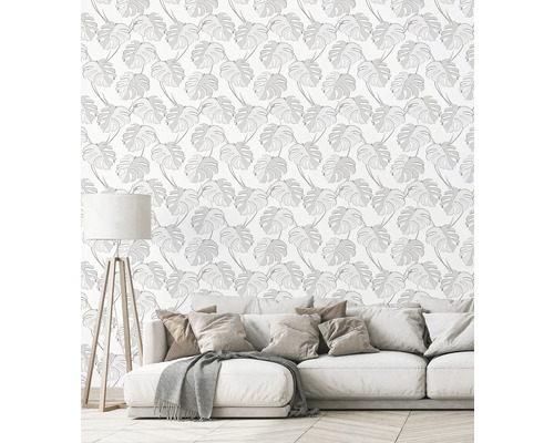 Wohnraum mit Sofa und Wandtapete mit Monstera-Blatt-Motiv
