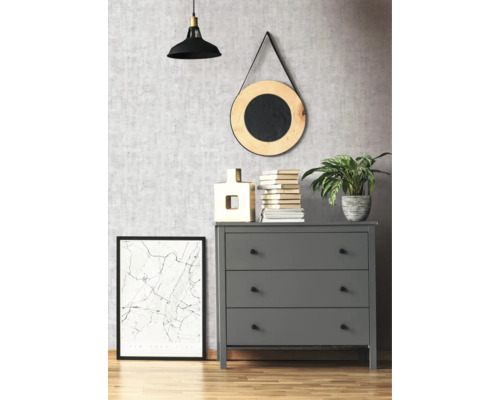 Graue Kommode mit drei Schubladen in einem Zimmer mit dekorativen Elementen wie einer Lampe, einem Spiegel und einem gerahmten Bild.