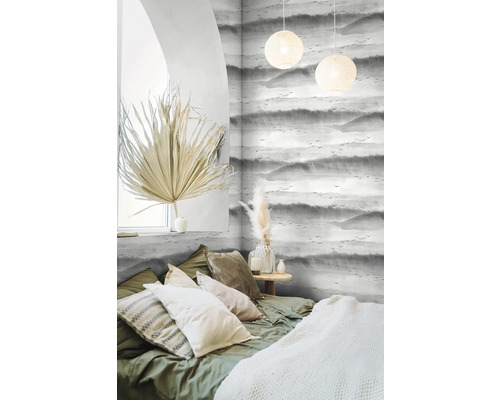 Helles Schlafzimmer mit gemusterten Tapeten, Bett und dekorativen Elementen