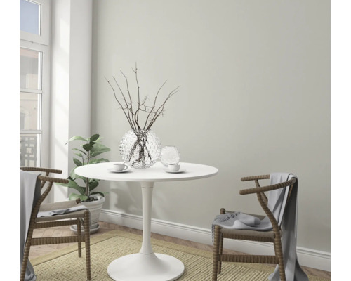 Helle, freundliche Essecke mit rundem Tisch, zwei Stühlen, Dekoration und Zimmerpflanze.