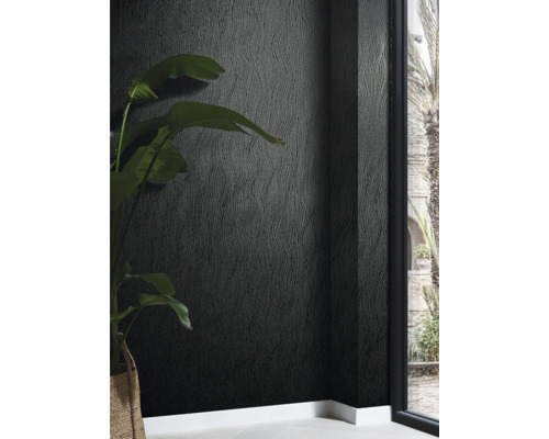 Nahaufnahme einer Wand mit dunkler Strukturtapete und einer Zimmerpflanze