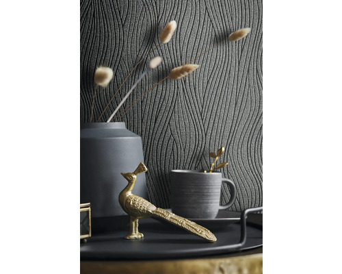 Dekorative Szene mit gemusterter Tapete, Vase, Tasse und goldfarbener Pfauenfigur