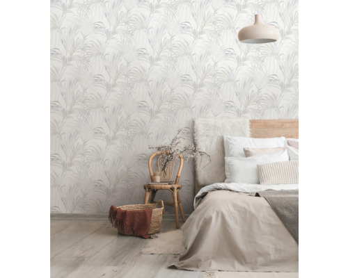 Ein Schlafzimmer mit einer Wand, die mit einer Tapete mit Pflanzenmuster verziert ist, einem Bett und einem Stuhl.