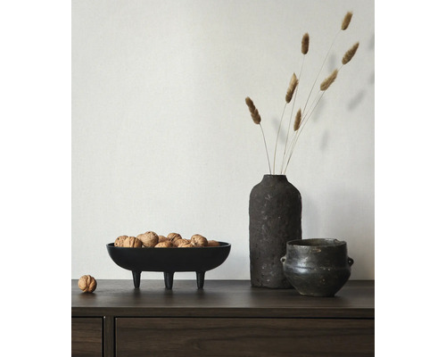 Dekoratives Arrangement mit einer Schale auf Füßen gefüllt mit Walnüssen, einer Vase mit getrockneten Blumen und einem Topf.