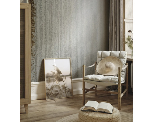 Wohnzimmer mit strukturierten Tapeten, Sessel und Dekorationen für ein helles und gemütliches Ambiente.