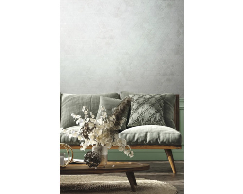 Wohnzimmer mit Sofa, Kissen, Tisch und geometrischer Tapete