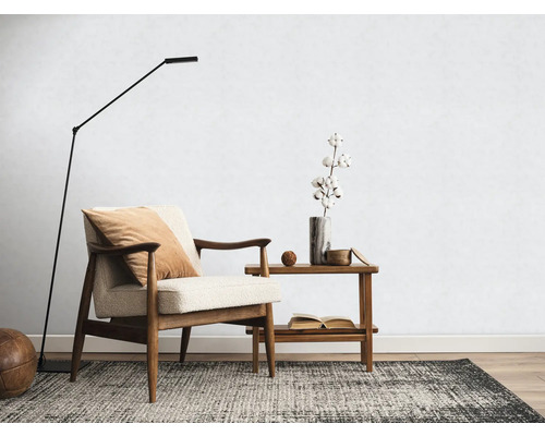 Wohnzimmer mit Sessel, Stehlampe, Teppich und Beistelltisch