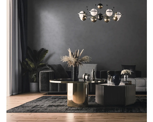 Wohnzimmer mit Couch, Tisch und Zimmerpflanze unter einer dekorativen Lampe