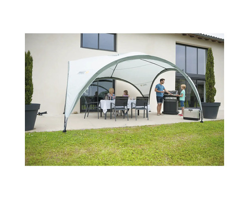 Familie unter einem Pavillon im Garten beim Grillen