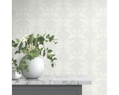 Tapete mit floralem Muster hinter weißen Vasen auf einem Tisch.