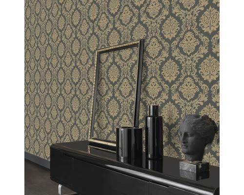 Wohnraum mit gemusterter Tapete, Rahmen, Vasen und einer Büste auf einem Schrank