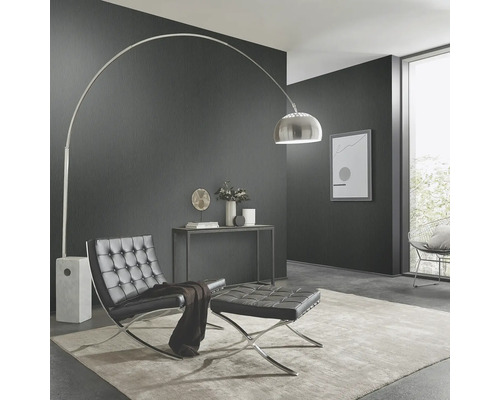 Wohnzimmer mit Bogenlampe, Sessel und Hocker