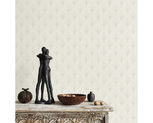 Einrichtungsidee mit gemusterter Tapete, Skulptur und Holzschale auf einem Tisch