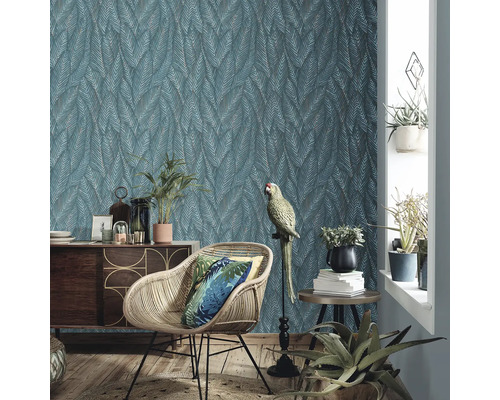 Wohnzimmer mit gemusterter Tapete, Rattansessel und Dekoration