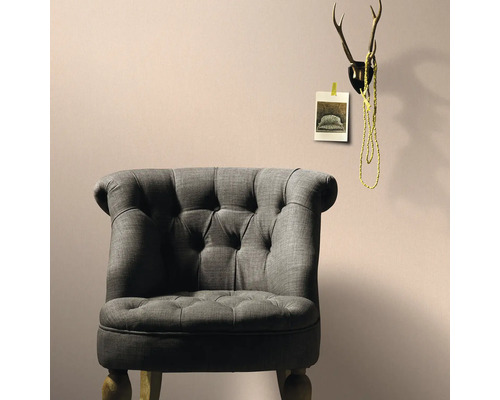 Grauer Sessel im Wohnzimmer mit Geweih-Dekoration an der Wand