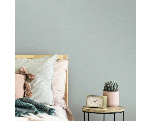 Schlafzimmer mit Bett, Nachttisch, Uhr, Sukkulente und Textiltapete