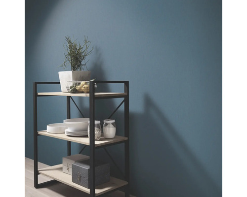 Regal mit drei Ablagen, Geschirr und Dekoration vor einer Wand