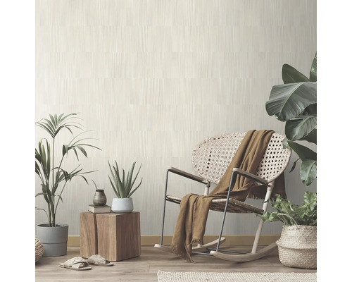 Heller Wohnraum mit gemusterter Tapete, Schaukelstuhl und Zimmerpflanzen für eine freundliche Atmosphäre.