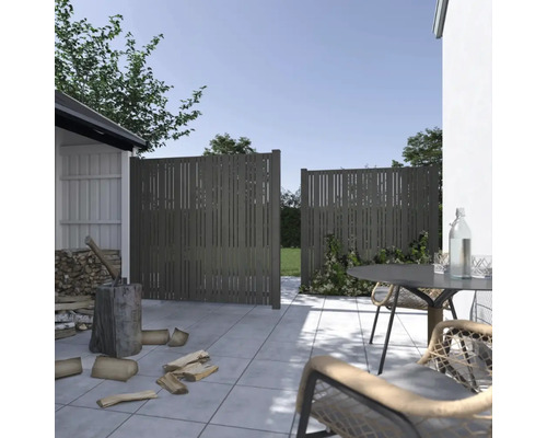 Gartenszene mit Zaunelementen, Gartenmöbeln und Brennholz