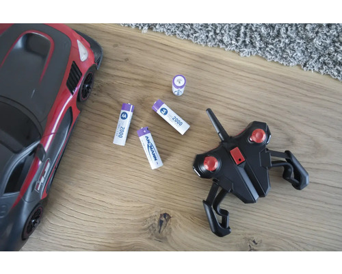 Spielzeugauto mit Fernbedienung und Batterien auf einem Holzboden