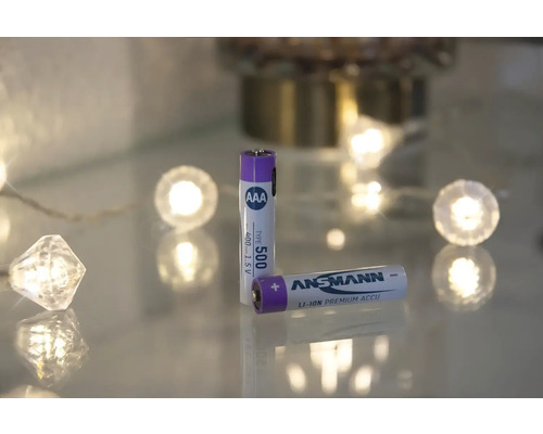 Zwei Ansmann AAA-Akkus liegen auf einer Glasoberfläche