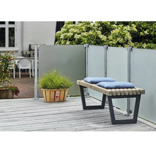 Terrassenszene mit Windschutzwand, Holzbank mit Kissen und Topfpflanze