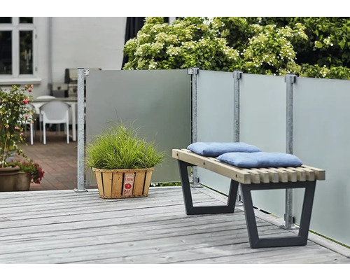 Terrassenszene mit Windschutzwand, Holzbank mit Kissen und Topfpflanze