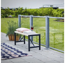 Bank mit Metallgestell, Kissen, Büchern und Weinglas auf einer Terrasse