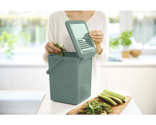 Komposteimer mit Deckel und Gemüseabfällen