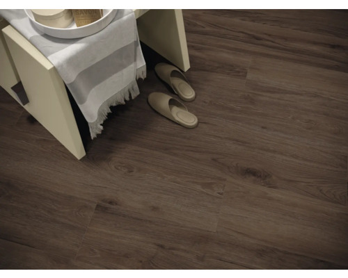 Innenaufnahme eines Zimmers mit Laminatboden in Holzoptik, einem kleinen Hocker und Hausschuhen.