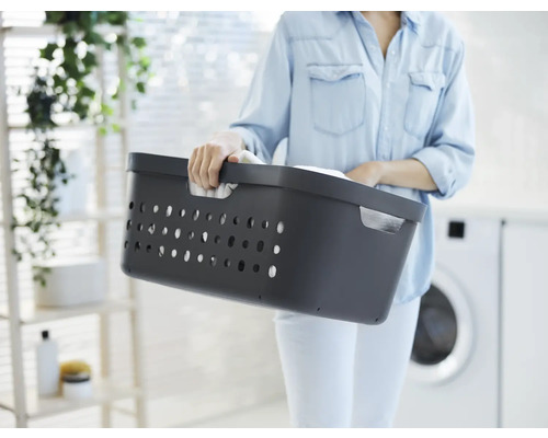 Frau hält Wäschekorb aus Kunststoff
