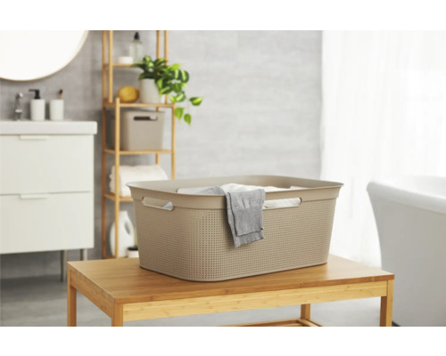 Wäschekorb aus Kunststoff auf einem Holztisch im Badezimmer