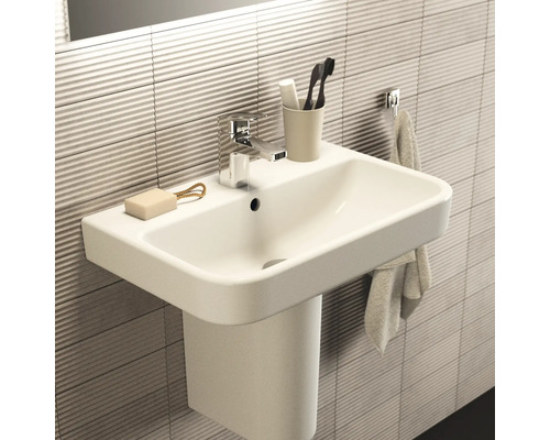 Waschbecken mit Armatur, Seife, Zahnbürsten und Handtuch im Badezimmer