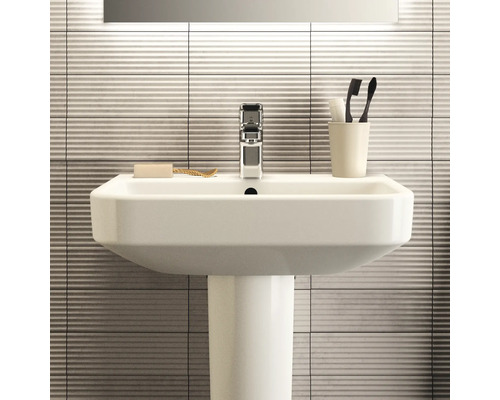 Waschbecken mit Waschtischsäule, Armatur, Seife und Zahnbürsten im Badezimmer