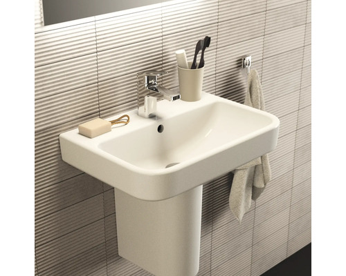 Modernes Badezimmerwaschbecken mit Armatur, Seife, Zahnbürste und Handtuch.