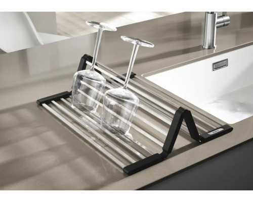 Abtropfgestell mit Gläsern auf einer Küchentheke neben einem Spülbecken.