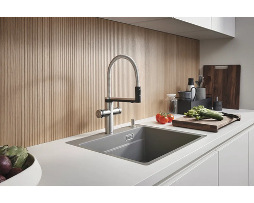 Küchenszene mit Spüle, Armatur und Lebensmitteln auf der Arbeitsplatte