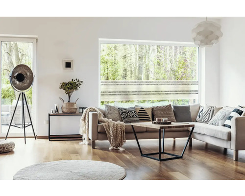 Wohnzimmer mit Sofa, Couchtisch, Stehlampe und dekorativen Kissen