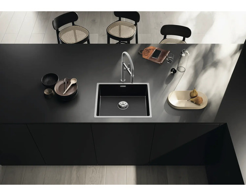 Küchenspüle mit Armatur auf einer Küchentheke mit Geschirr und Dekoration