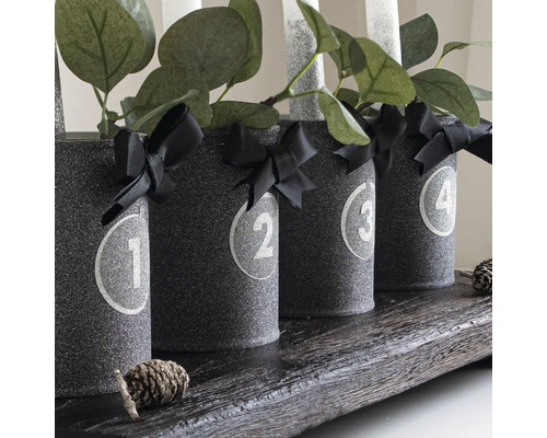 Adventskranz mit Zahlen, Schleifen, Kerzen und Dekoration auf Holztablett