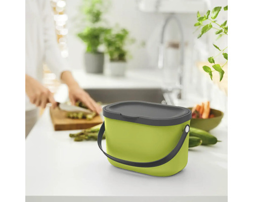 Grüner Komposteimer mit Deckel auf einer Küchentheke