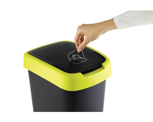 Person wirft Flasche in einen Abfalleimer mit Recycling Symbol