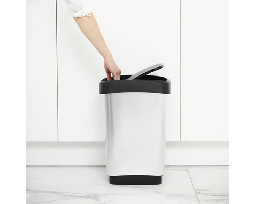 Person öffnet einen Abfallbehälter aus Metall im Badezimmer